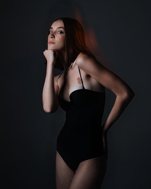 A woman in a black bodysuit posing for a photo