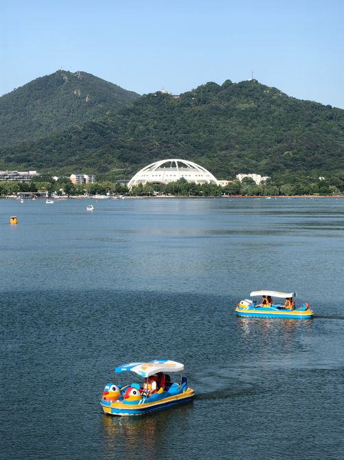 Free Pedal boats on a lake with mountains and a distinctive dome in Jiangsu Province, China. Stock Photo