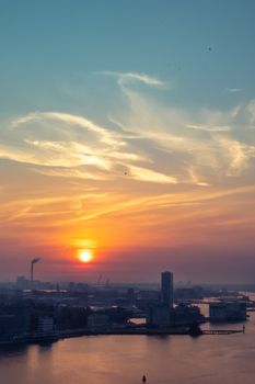 Breathtaking view of Amsterdam skyline at sunrise with vibrant colors spreading across the sky.