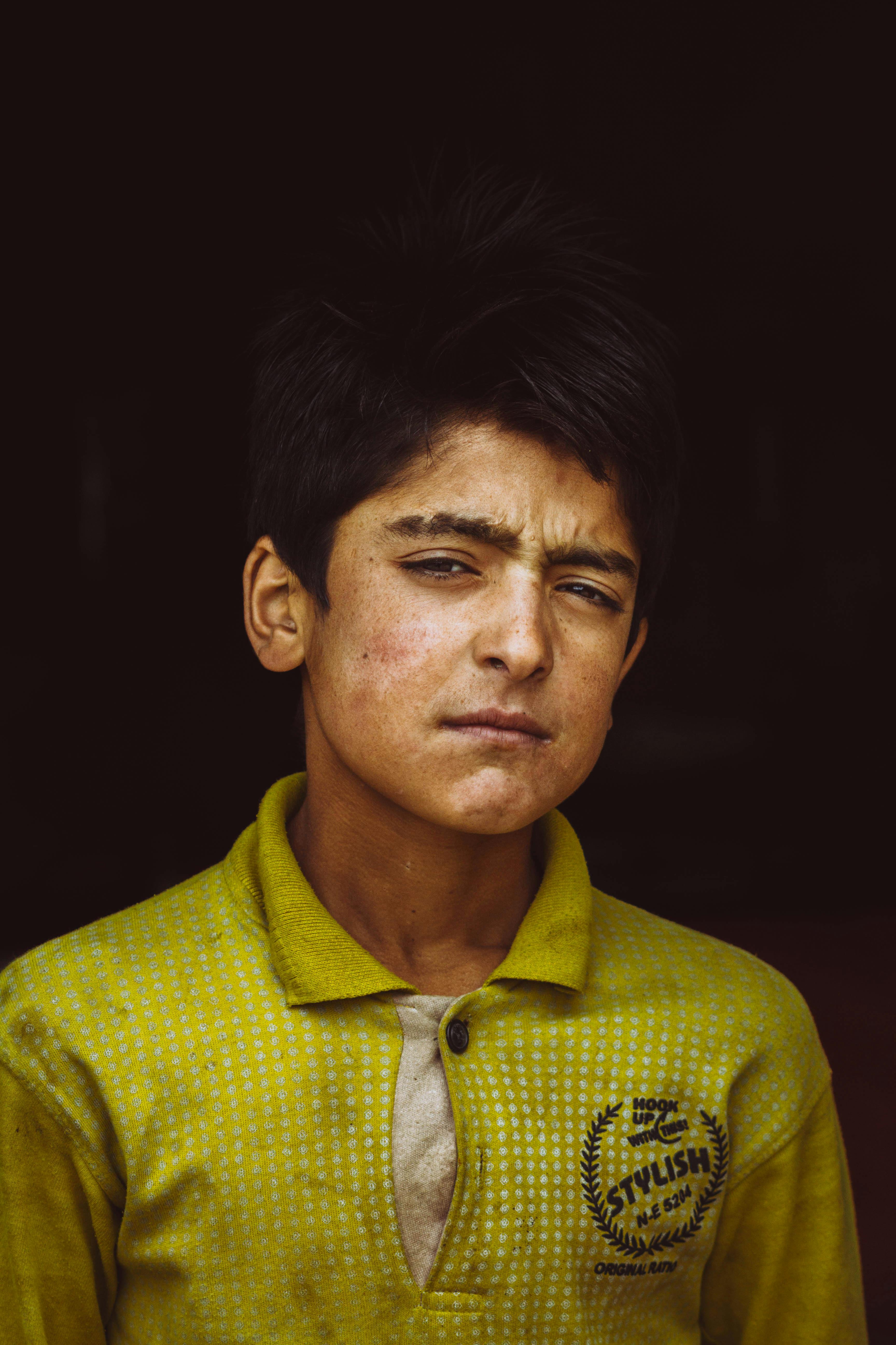 portrait photo of boy in yellow polo shirt