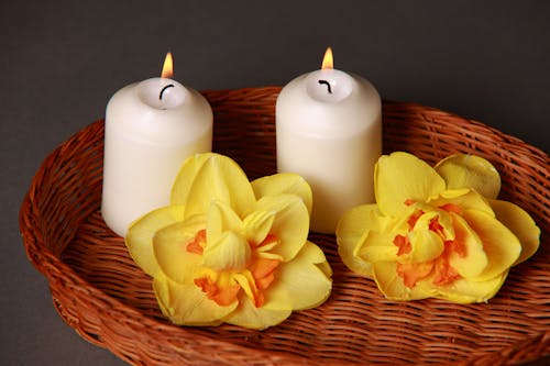Lighted White Candles Near Yellow Petaled Flowers