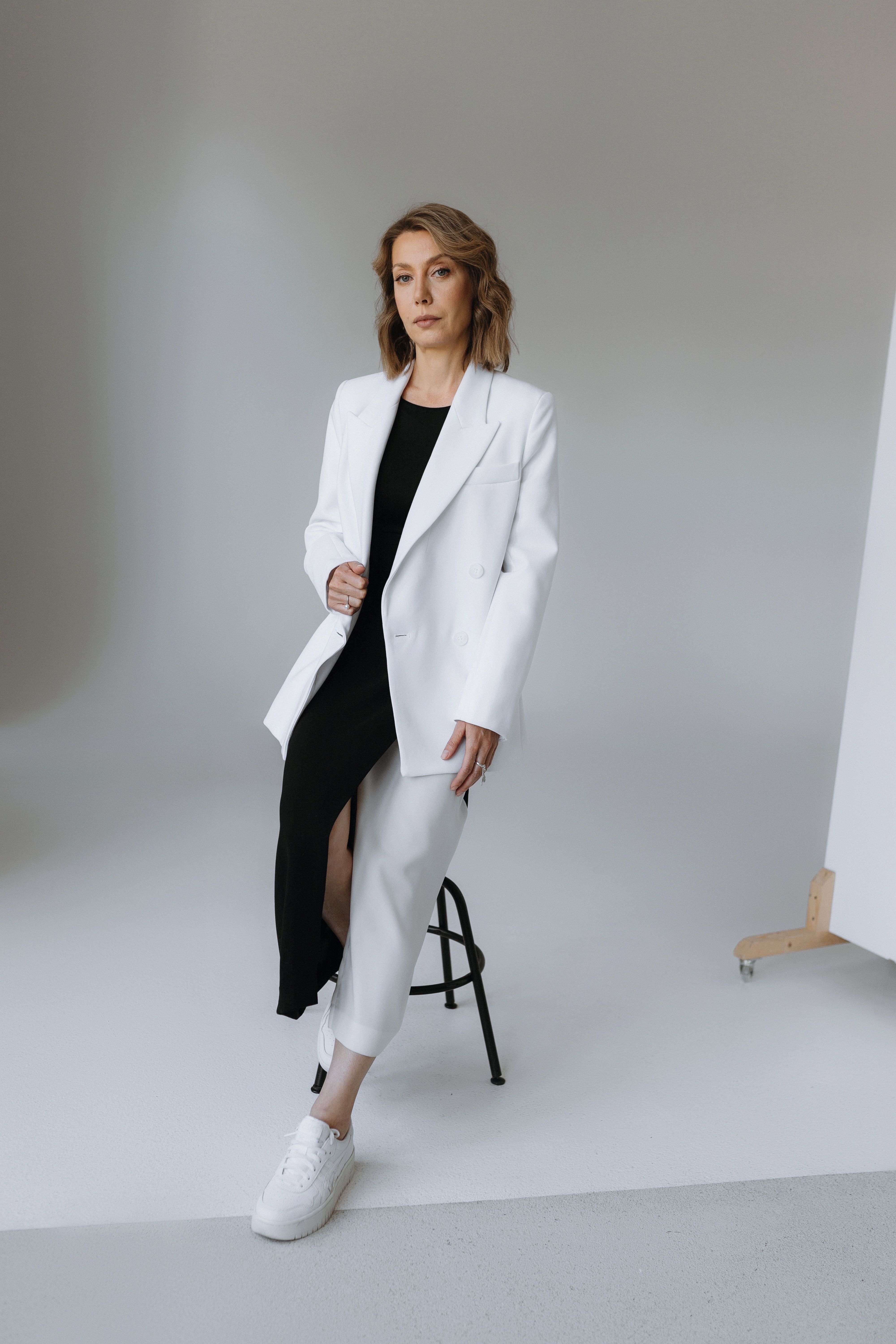 Woman Sitting in White Suit · Free Stock Photo