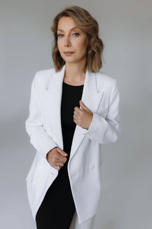 A woman in a white blazer and black dress
