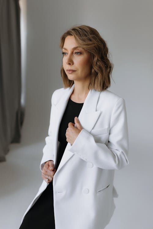 A woman in a white blazer and black pants