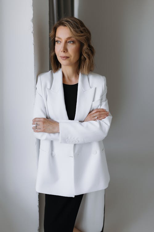 A woman in a white blazer and black pants