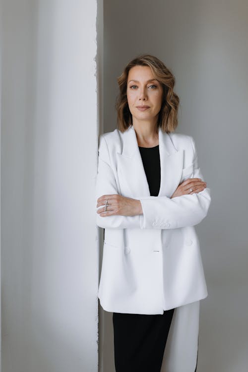 A woman in a white blazer and black dress