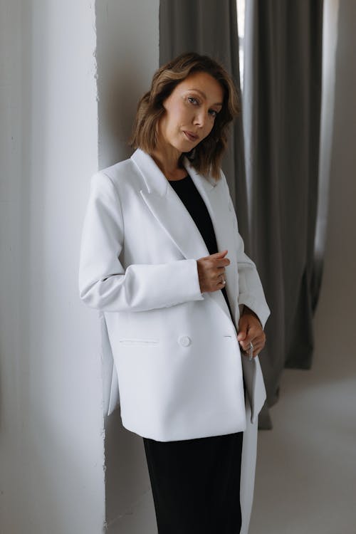 A woman in a white blazer and black pants