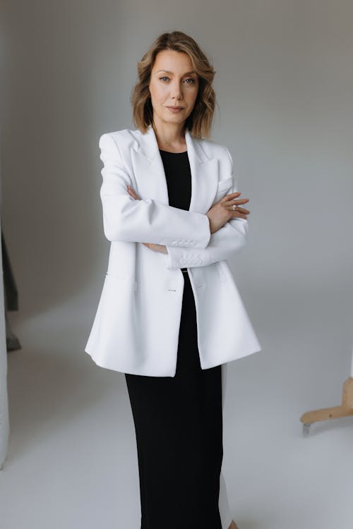 A woman in a white blazer and black dress
