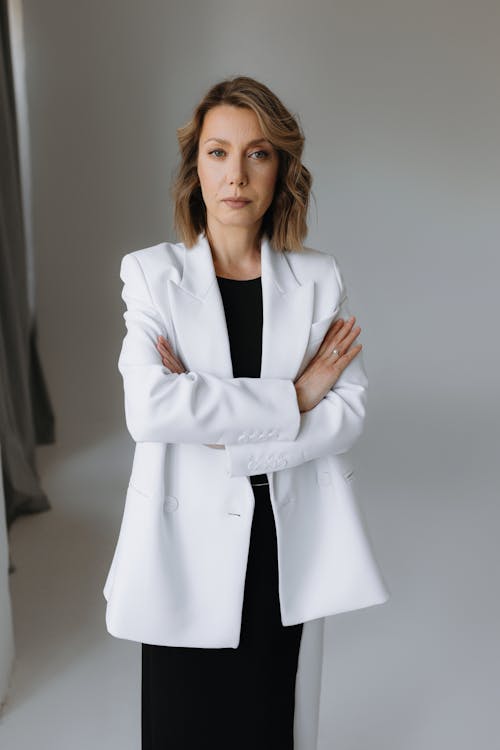 A woman in a white blazer and black dress