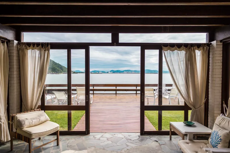 Sunlit interior with open doors onto sea view terrace