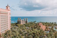 巴哈马拿骚海边豪华度假胜地的鸟瞰图，以粉红色塔楼和郁郁葱葱的棕榈树为特色