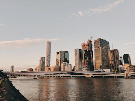 Stunning Brisbane skyline captured at sunset with the river in the foreground, showcasing urban architecture.