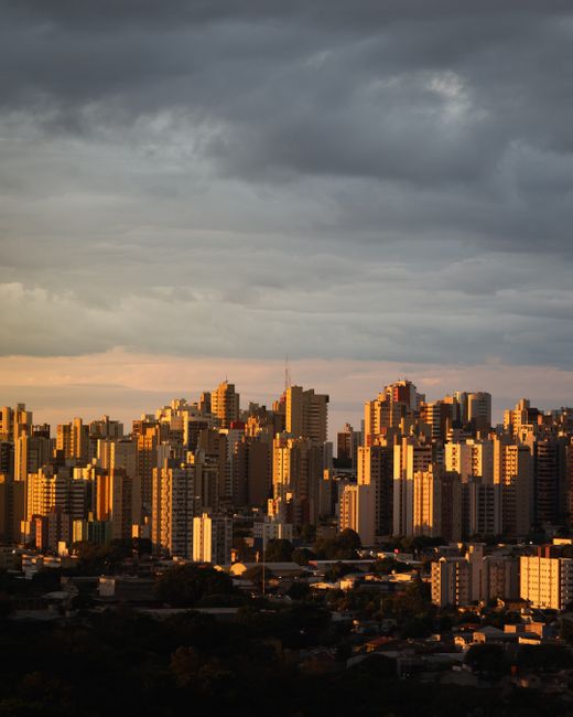Vibrant cityscape at twilight with a dramatic sky, showcasing urban architecture.