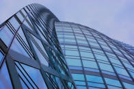 低角度拍摄的日本东京一座现代玻璃摩天大楼，映衬着蓝天倒影