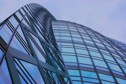 低角度拍摄的日本东京一座现代玻璃摩天大楼，映衬着蓝天倒影