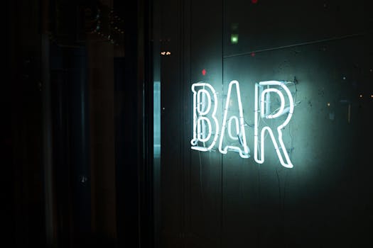 A glowing neon 'BAR' sign casting a bright light on a quiet Tokyo street at night.