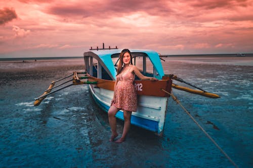 Photo of a Woman Standing Near a Boat