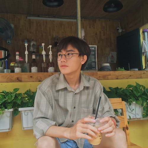 Photo of a Man in Button-up Collared Shirt Holding a Beverage