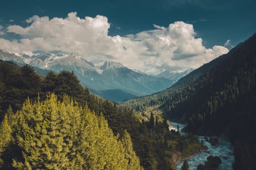 Free Breathtaking aerial view of a forested mountain valley with a winding river. Stock Photo