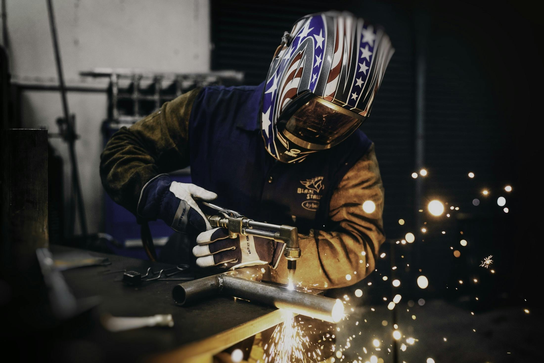 HD wallpaper man welding black metal man holding welding mask while  welding  Wallpaper Flare