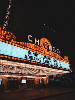 The illuminated marquee of the Chicago Theatre shines bright showcasing upcoming events.