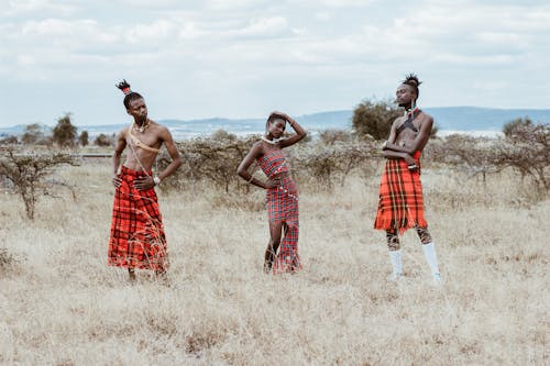 Foto Von Drei Personen, Die Rote Stammeskleidung Tragen