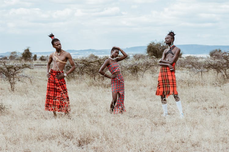 Photo Of Three People Wearing Red Tribal Clothes