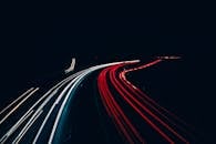 长曝光镜头捕捉夜间高速公路上车辆的光路，形成动态图案