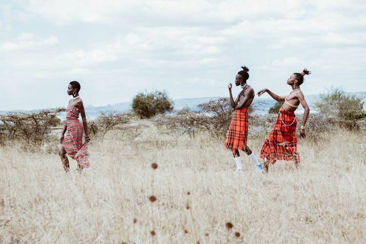 Photo Of People Walking On Grassland