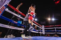 拳击手在比赛中获胜后，被教练和观众举起庆祝