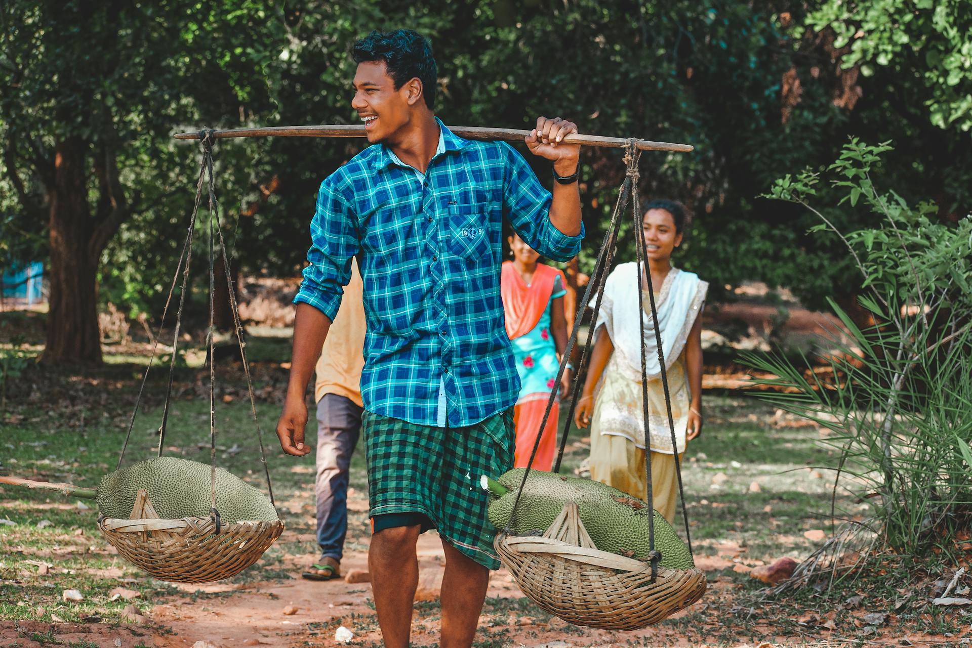 Photo of Man Carrying Two Baskets