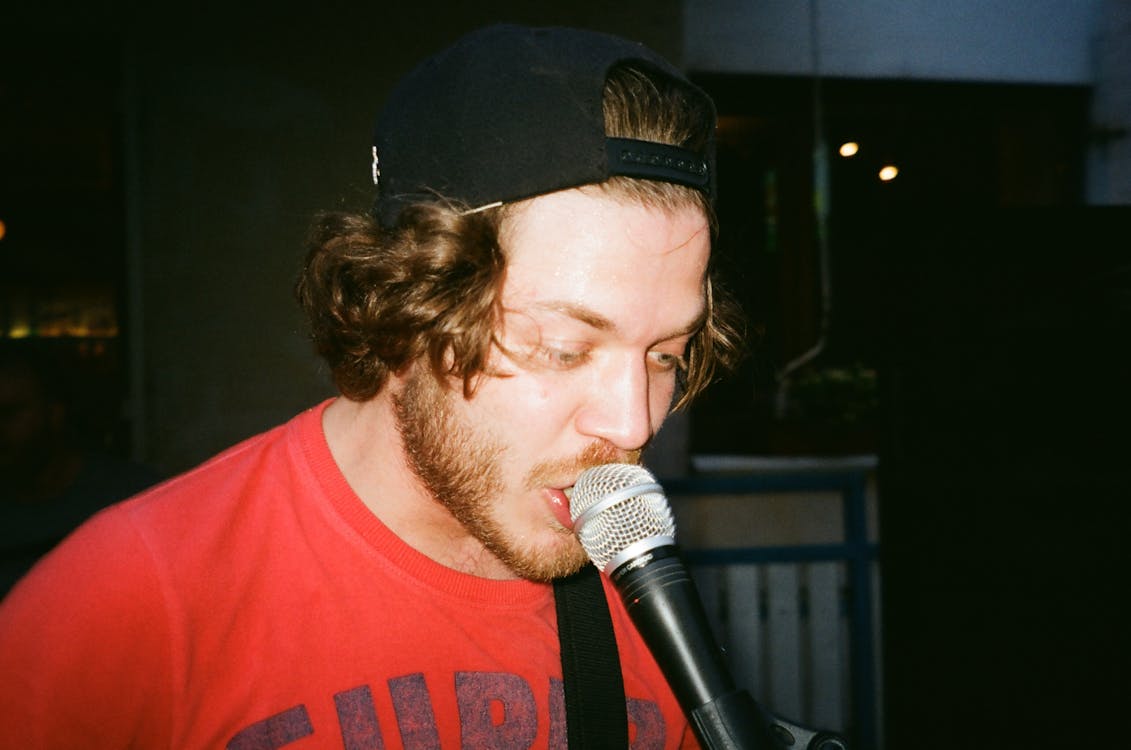Close-Up Photo of Man Singing Using a Dynamic Microphone