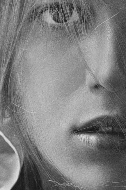 Artistic close-up portrait of a woman in black and white with dramatic lighting.