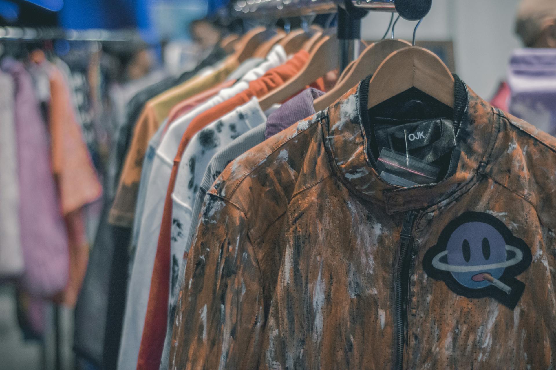 Colorful clothes hanging on a rack in a trendy retail store, showcasing fashion variety.