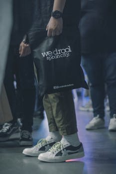 在时尚活动中，休闲装搭配运动鞋和手提包，展现了现代都市风格