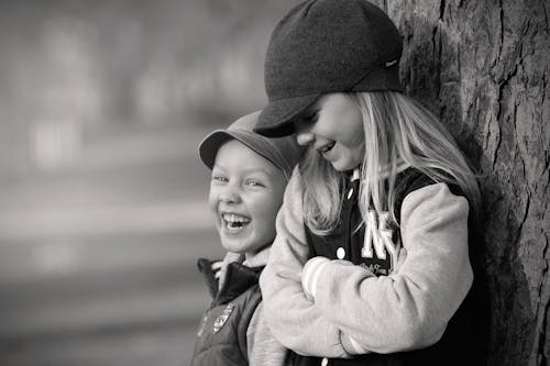 Boy and Girl Leaning on Tree