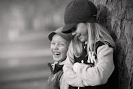 公园树旁，两个孩子欢笑的肖像展现了友谊与幸福