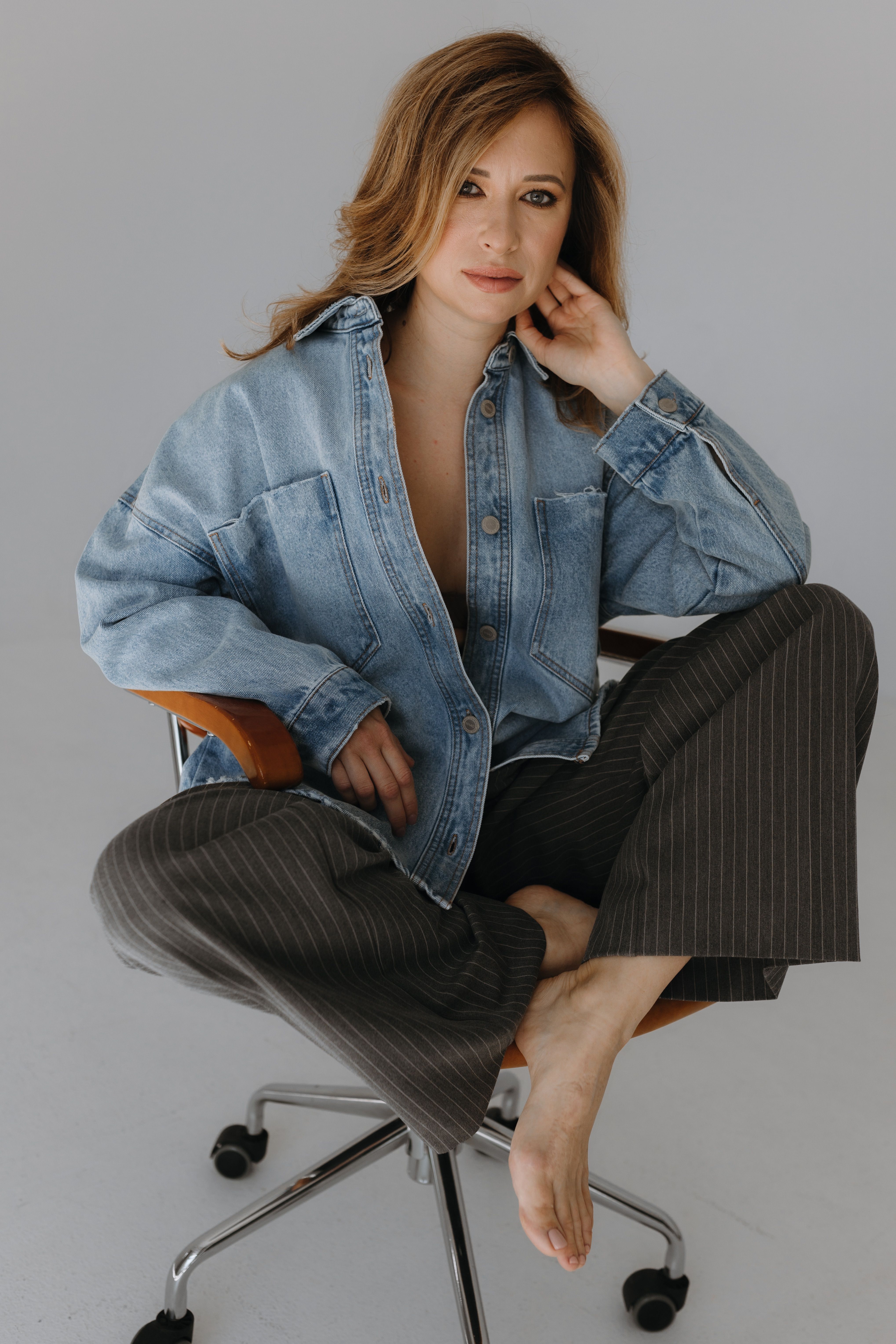 Woman in Denim Shirt Sitting on Chair an Fixing Hair · Free Stock Photo