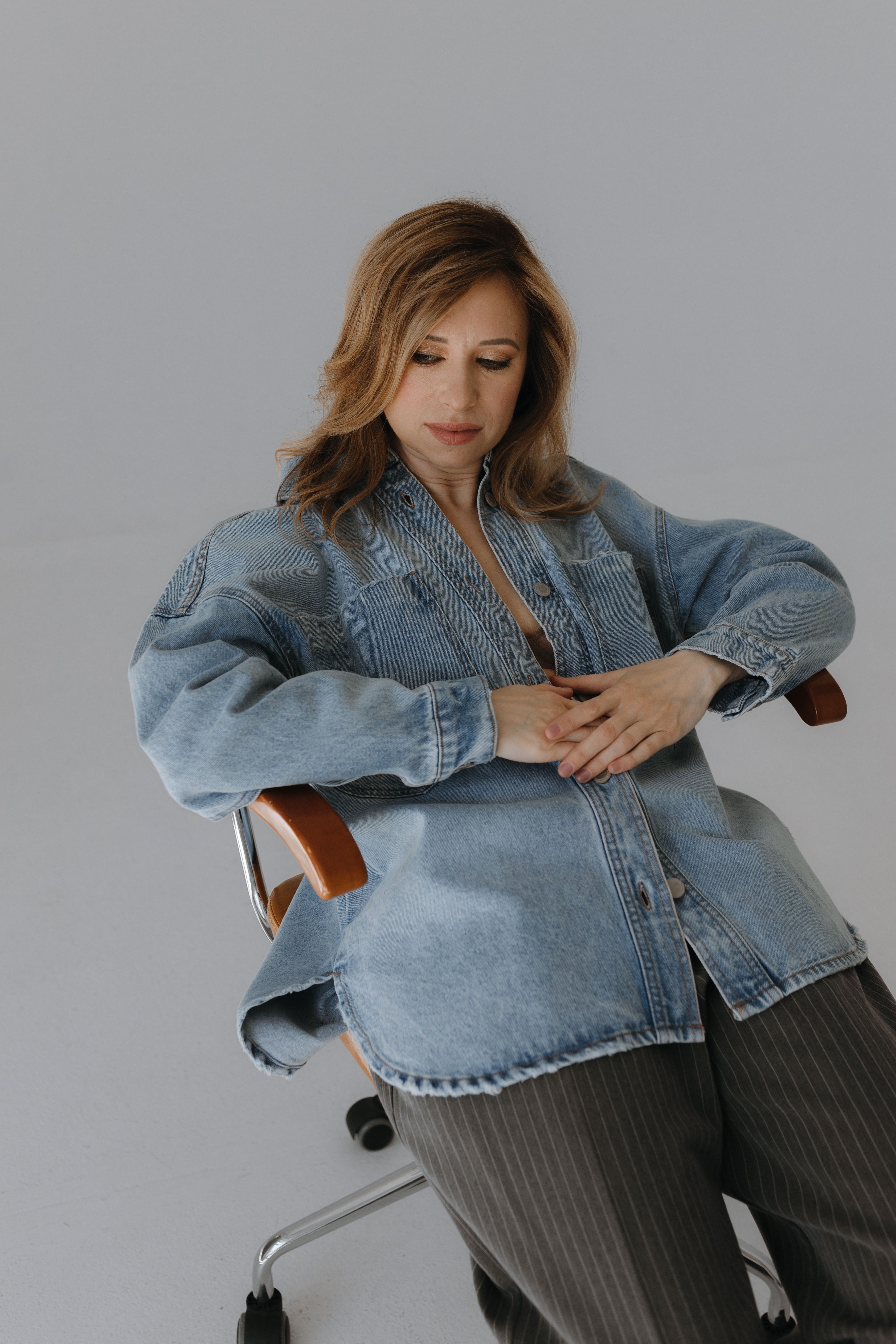 Woman in Jean Jacket Leaning on Chair · Free Stock Photo