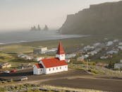 鸟瞰标志性的红顶维克教堂，沿着令人惊叹的冰岛海岸线俯瞰埃斯德兰加海塔