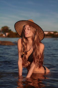 一位身着泳装的美丽女子在宁静的户外水景中摆着姿势