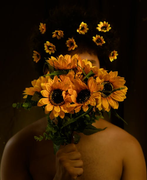 Photo of Person Holding Sunflowers