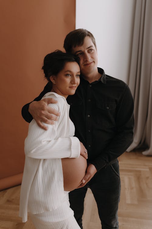 A pregnant woman and her husband pose for a maternity photo