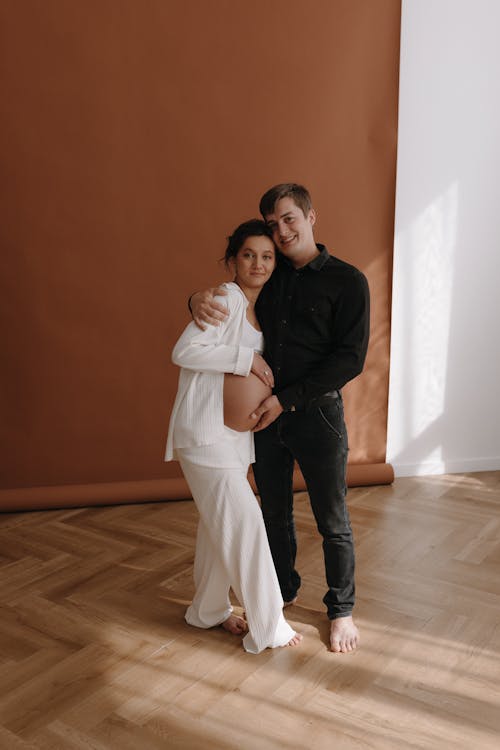 A man and woman are standing in front of a wall