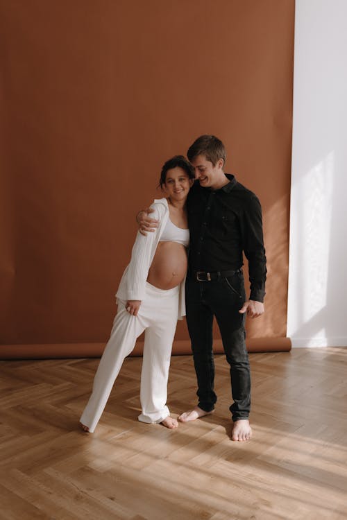 A pregnant woman and her husband pose for a maternity photo