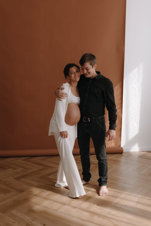 A pregnant woman and her husband pose for a photo