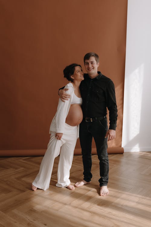 A pregnant woman and her husband pose for a photo