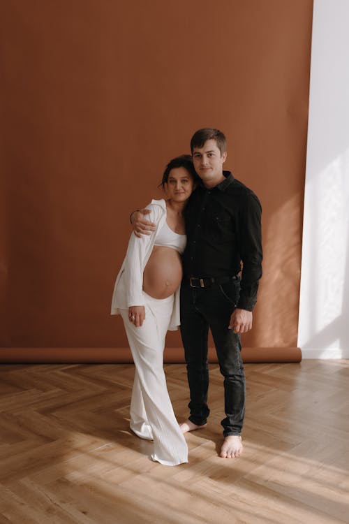 A pregnant woman and her husband pose for a photo