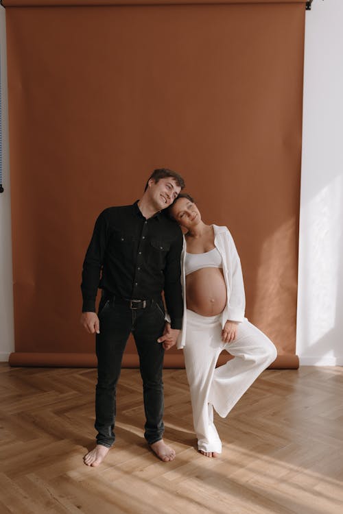 A pregnant woman and her husband pose for a maternity photo shoot