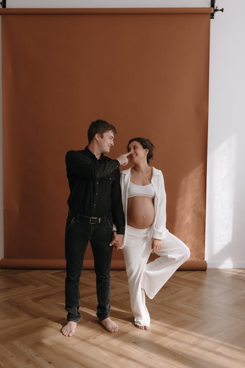 A pregnant woman and her husband pose for a maternity photo shoot